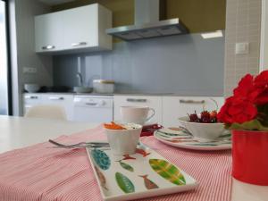 a table with two plates and two cups and flowers at Brisa Marina in A Guarda +25 photos