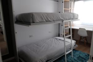 two bunk beds in a room with a desk at Brisa Marina in A Guarda