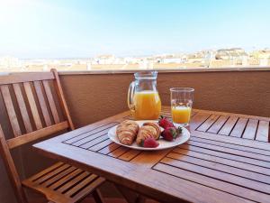 einen Tisch mit einem Teller Essen und einem Glas Orangensaft in der Unterkunft Sunrise Apartment 3BR (Free Wi-Fi) in Peniche