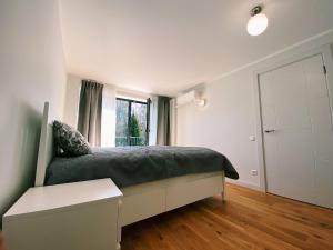 Schlafzimmer mit einem Bett und einem Fenster in der Unterkunft Albatross Mini - 2 Room Seaside Air-conditioned Apartment with Balcony in Ķesterciems