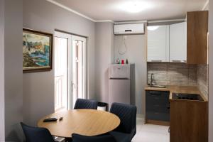 a kitchen with a table and chairs and a refrigerator at Guest House Mrvaljević in Budva