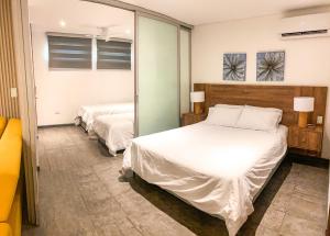 a bedroom with two beds and a mirror at Gz Tower Apartamento Barranquilla in Barranquilla