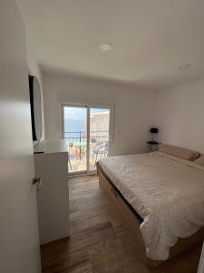 a bedroom with a bed and a view of the ocean at Requena12 in Villajoyosa