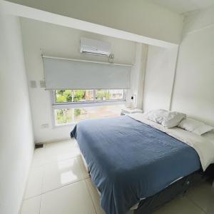 Un dormitorio con una cama azul y una ventana en Departamento Moritan II Sin Impuestos en Posadas