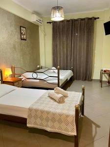 a bedroom with two beds and a table with towels at Villa Emmanouela Studios - Family Accommodation in Nea Vrasna