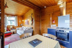 cocina y sala de estar con mesa y sofá en Harbottle Lodge, en Longframlington