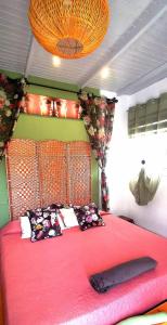 a bedroom with a pink bed with a large red headboard at Kikiki House in Puerto del Rosario