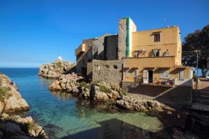a building on a cliff next to the water at Casa Liò in Santa Flavia
