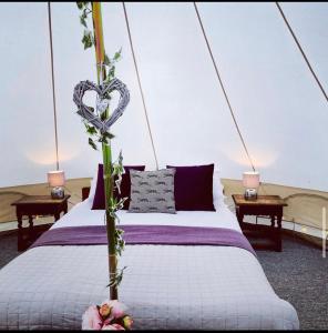 a bedroom with a bed with a heart decoration on it at Oxford Riverside Glamping in Oxford