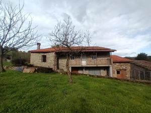 una vieja casa de piedra en un campo con un árbol en Casa Romina I, en Ferreira
