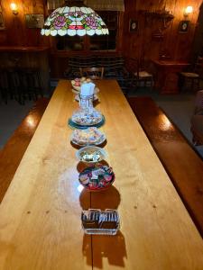 a long wooden table with plates of food on it at Turn of River Lodge in Killington