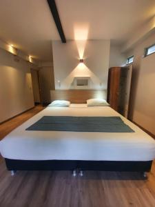 1 dormitorio con 1 cama blanca grande en una habitación en Carriqui Underground, en Pereira