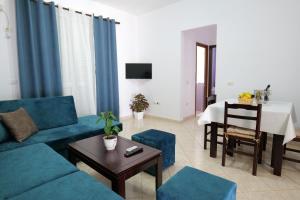 a living room with a blue couch and a table at Ernest Apartments in Sarandë