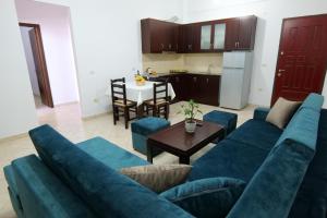 sala de estar con sofá azul y mesa en Ernest Apartments, en Sarandë