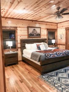 a bedroom with a bed and two tables and two lamps at Stone Mountain Lodge 5000sqft 6 Bed Game Room Pool Table Hot Tub in Broken Bow