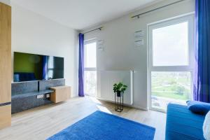 een woonkamer met een blauwe bank en een tv bij Stylish studio 2 Targowa 10, National Stadium in Warschau
