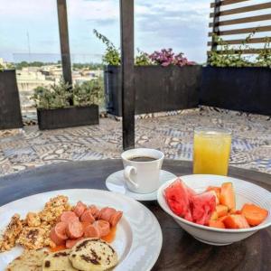 a table with two plates of food and a cup of coffee at Cienaguas Hotel in Ciénaga