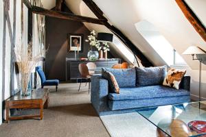 een woonkamer met een blauwe bank en een tafel bij L' Annexe du 10Honfleur in Honfleur