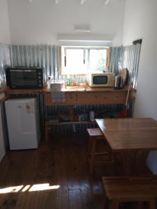 a kitchen with a table and a microwave and a refrigerator at je nous studio 3 in José Ignacio