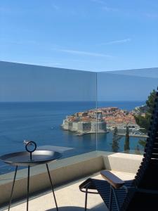 een balkon met een tafel en uitzicht op de oceaan bij New&Luxury Apartment with an Outstanding View - Bombii Blue in Dubrovnik