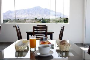 una mesa con un tazón de comida y un vaso de zumo de naranja en Hotel Tierra del Sol Moquegua, en Moquegua