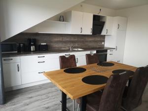 a kitchen with a wooden table and some chairs at Ferienwohnung Nord/Süd in Nordenham