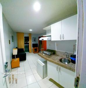 een keuken met een wastafel en een woonkamer bij American Flat - Ponta D'areia - Ferreira Hospedagens in São Luís