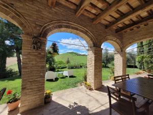 een patio met een tafel en stoelen bij Agriturismo Fiorano in Cossignano