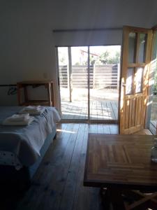 a bedroom with a bed and a sliding glass door at je nous studio 3 in José Ignacio