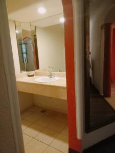 a bathroom with a sink and a mirror at Motel Astoria in Aguascalientes