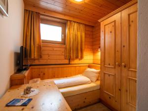 a small bedroom with a bed in a wooden cabin at Ferienhaus Oblasser II in Finkenberg