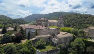 an old building in a town with mountains in the background at Gîte d'étape et de groupe du Clos Saint Roch in Viviers