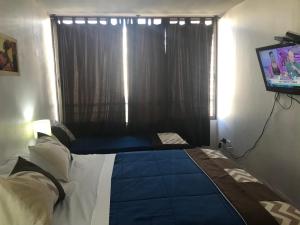 a bedroom with a bed and a television at Apartment Relocation San Isidro in Santiago