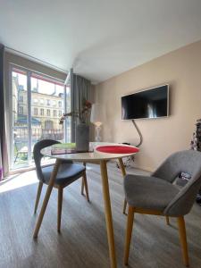 a living room with a table and two chairs at Romantique "comme à Venise" au bord de l'eau avec parking in Metz