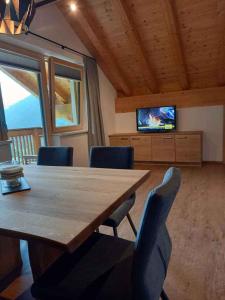 a dining room with a table and chairs and a television at Holiday home in Kappl Paznauntal 42411 in Kappl