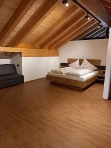 a bedroom with a bed and a couch and wooden ceilings at Holiday home in Kappl Paznauntal 42411 in Kappl