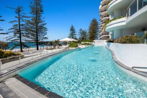 a swimming pool in front of a building at Sirocco 507 by G1 Holidays in Mooloolaba