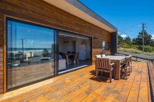 a patio with a table and chairs on a wooden deck at Bordaga Holiday Units - Unit 2 in Scamander