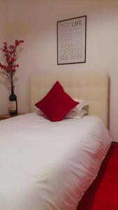 um quarto com uma cama branca e uma almofada vermelha em Unique & beautiful bedroom in central of Florence em Florença