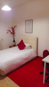 Unique & beautiful bedroom in central of Florence في فلورنسا: غرفة نوم بسرير أبيض مع سجادة حمراء