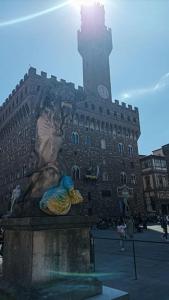 uma estátua em frente a um edifício com uma torre de relógio em Unique & beautiful bedroom in central of Florence em Florença