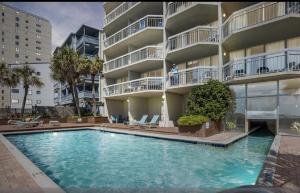 a swimming pool in front of a apartment building at 1108 Waters Edge Resort condo in Myrtle Beach