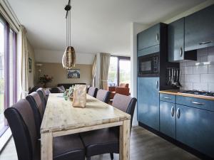a kitchen and dining room with a table and chairs at Cozy holiday home with two bathrooms, in Zeeland in Heinkensand