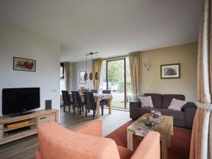 a living room with a couch and a table with chairs at Cozy holiday home with two bathrooms, in Zeeland in Heinkensand