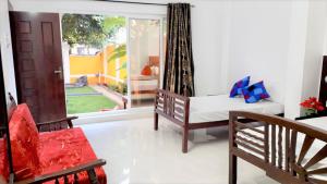 Cette chambre comprend un lit, une chaise et une fenêtre. dans l'établissement Chan Maison @ Lakshmi Gardens, à Pondichéry