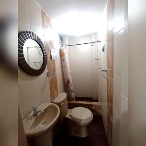 a bathroom with a toilet and a sink and a mirror at Hotel la encantada in Cajamarca