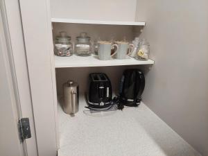aessedessedessedessed room with cups and appliances on shelves at The Grey Studio@13a in Carterton