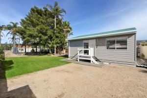 ein kleines Haus mit Veranda und Garten in der Unterkunft The Beaches on Lakes Cottage in Lakes Entrance + 2 Fotos