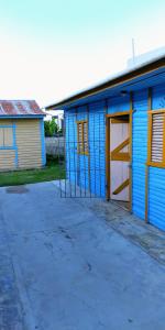 a blue building with a door and a garage at El Conde del Macao in Salado