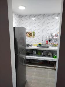 Il comprend une cuisine équipée d'un réfrigérateur en acier inoxydable. dans l'établissement APARTAMENTO VACACIONAL MELGAR, à Melgar